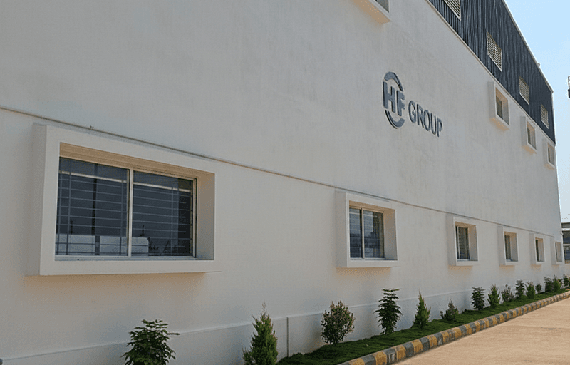 Exterior view of the white factory building in Bangaluru, India, which belongs to the HF GROUP