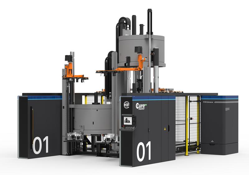 Large electric tyre curing press with central round modules, protective cladding and vertical superstructures.