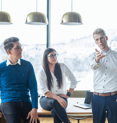 Two men and a woman are discussing in the office.