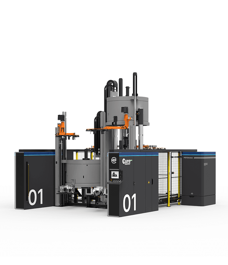Large electric tyre curing press with central round modules, protective cladding and vertical superstructures.